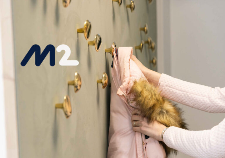 Kuvassa M2 matkahallintajärjestelmän logo Certian toimistotilojen kuvituskuvan kanssa.