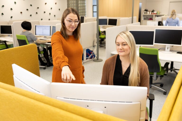 kaksi naista tietokoneen äärellä Certian toimistossa.